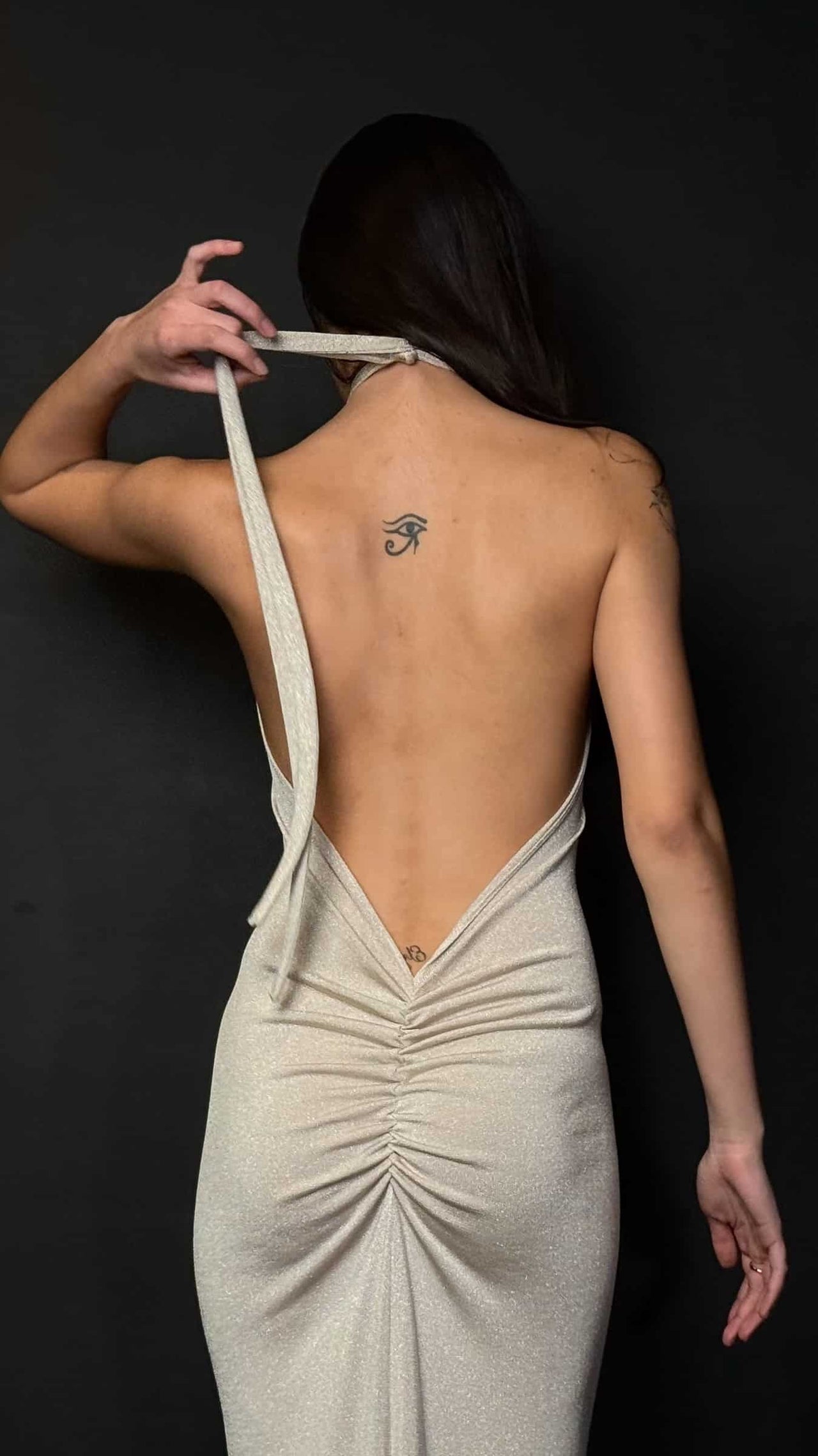 Woman in a long, elegant dress against a dark background